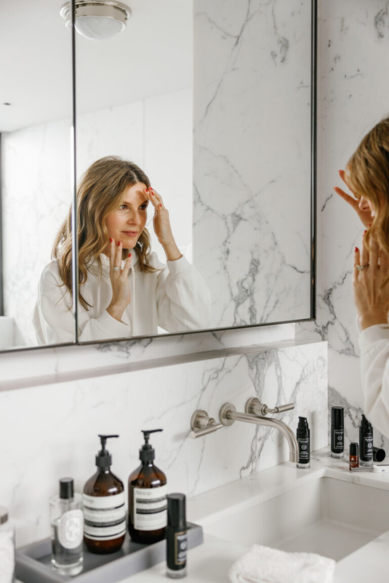 woman washing face in mirror 865x1296